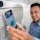 A mail carrier uses an NFC phone to record a mailbox delivery