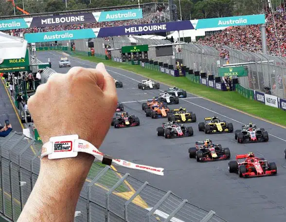 Hand with tappit wristband and F1 race track and cars