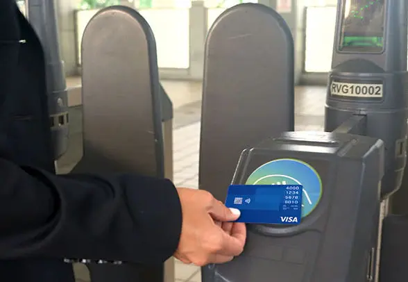 A passenger pays for a fare with a contactless card at a Metrorail ticket barrier