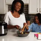 A mother and daughter cooking with Ki Cordless Kitchen appliances