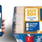 Hand holding smartphone next to pack of Kraft Single cheese