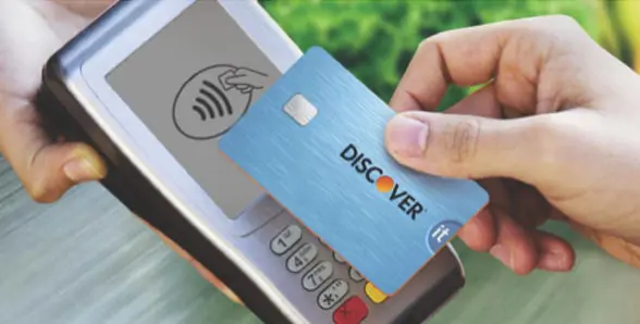 Contactless Discover It card being tapped on payment terminal