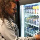 Woman using nfc phone to buy item from vending machine