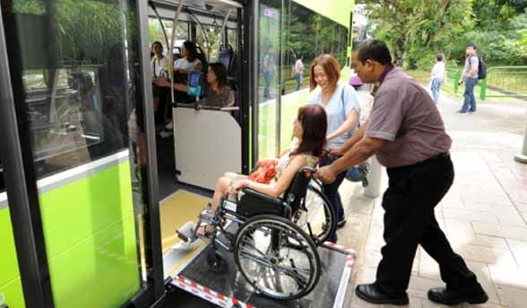 Singapore woman in wheelchair being helped onto LTA bus
