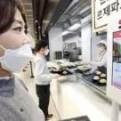 Woman wearing mask using LG CNS biometric payment POS