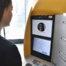 Woman using Caixabank Store biometric atm