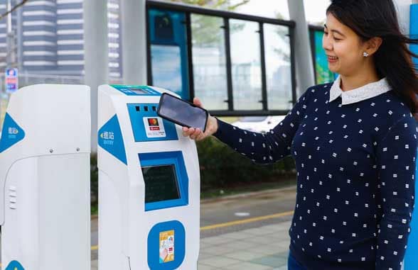 Girl using New Taipei Metro Corporation mobile ticket payments reader