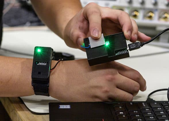 Prototype wearable showing smartwatch transferring data to laptop