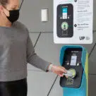Woman tapping contactless debit card on UP payment terminal
