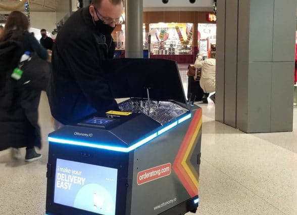 Man accessing contactless retail delivery robot at Cincinnati airport