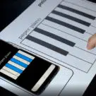 Fingers on keyboard of ultra-thin NFC-powered paper piano