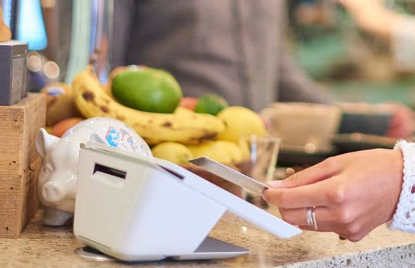 UK shopper making contactless transaction with card on terminal