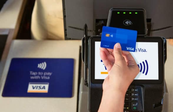 Visa cashless contactless card being tapped on payment device