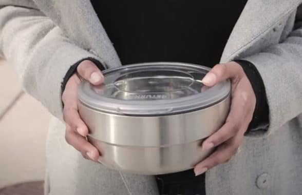 Hands holding reusable NFC food container 