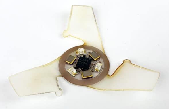 Closeup of miniature batteryless flying microchips with NFC