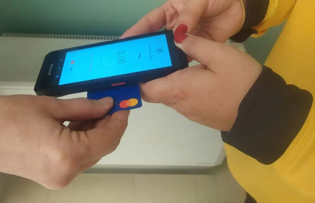 Correos postal delivery staff accepting contactless payments on Android device in Spain