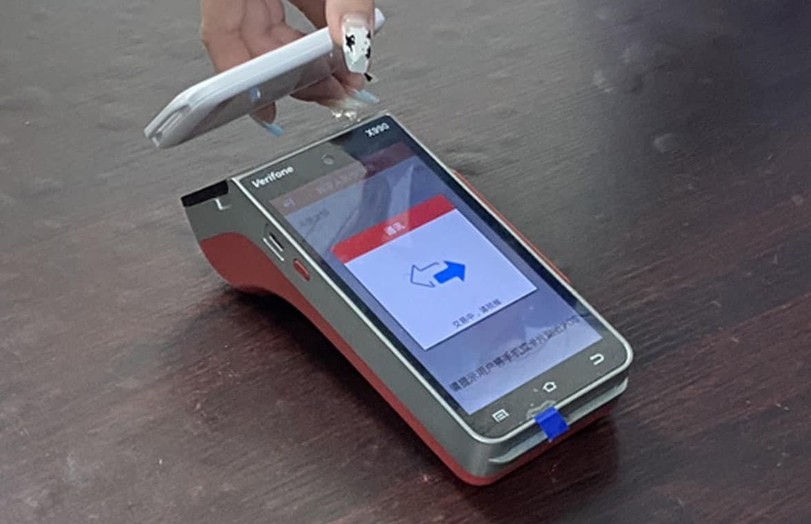 School student using digital yuan hard wallet to make CBDC payment using NFC