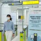 Woman passing through tagless bluetooth gate on Korean subway