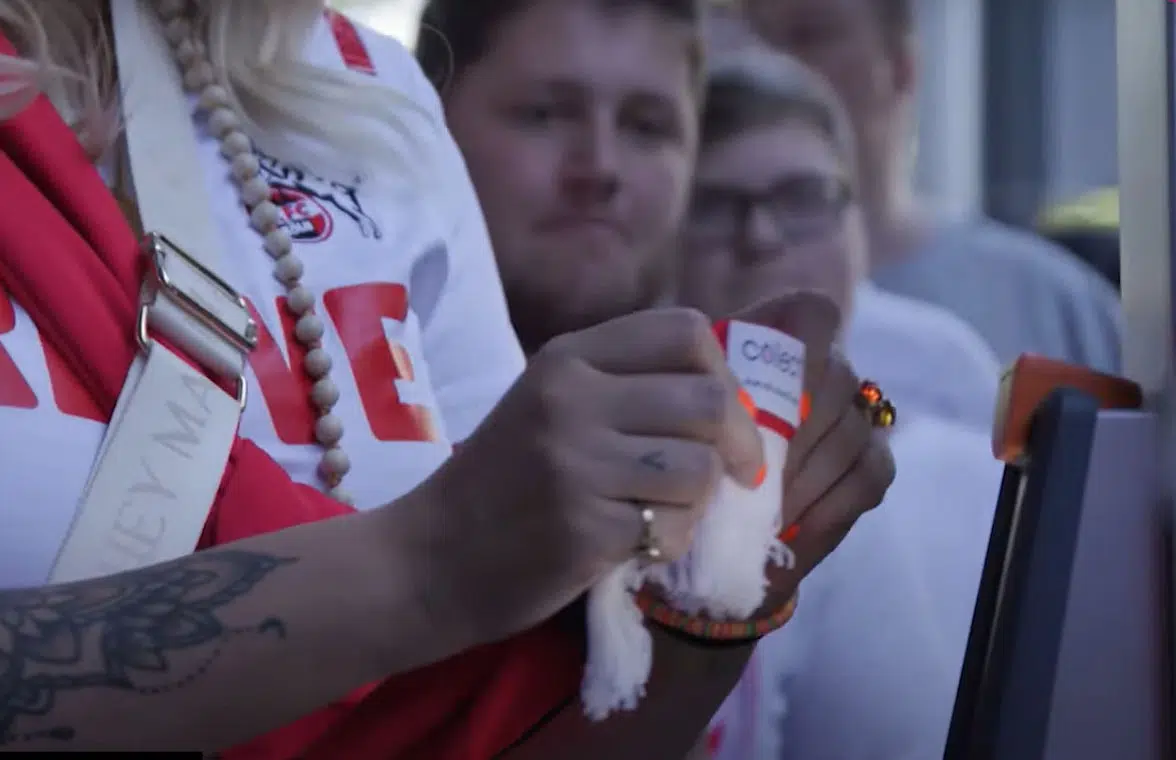Woman using team scarf with NFC chip to pass through gates at German football club