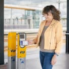 Woman making contactless open loop payment at Dutch train station using smartphone