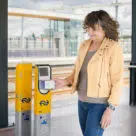 Woman making contactless open loop payment at Dutch train station using smartphone
