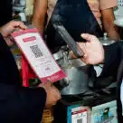 Customer using Bangladesh Bank's interoperable QR code payments system to pay for goods with their mobile