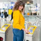 Woman making contactless open loop payment at Dutch train station using a credit card