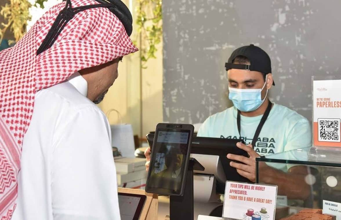 Customers making in-store contactless payments with their face using Qatar National Bank system
