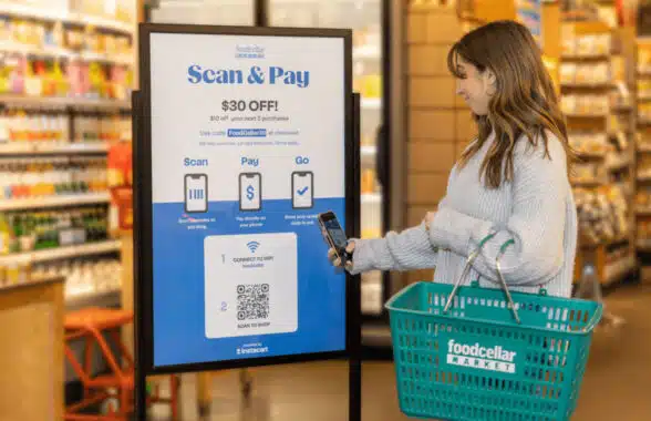 Woman using Foodcellar contactless scan and pay shopping system in new york store