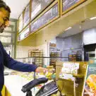Customer using Amazon One at US bakery-cafe chain Palmera to make biometric palm payment