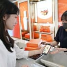 A shopper making payment at a Lotte Duty Free outlet who has added their passport to its mobile app for passport-free duty free shopping