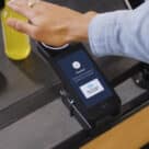 Woman using Amazon contactless pay by palm technology to pay for goods at Whole Foods Market in the USA