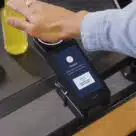 Woman using Amazon contactless pay by palm technology to pay for goods at Whole Foods Market in the USA