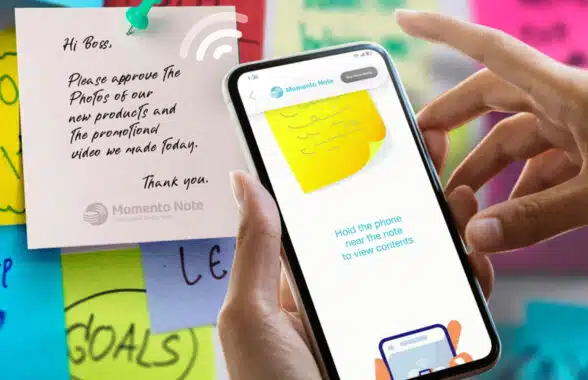Person holding an NFC phone over a Memento Note smart sticky note