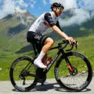 Tour de France cyclist on a mountain road wearing NFC cycling shoes that store medical records and emergency contact details