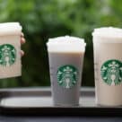 Three Starbucks returnable and reusable cups filled with beverages