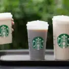 Three Starbucks returnable and reusable cups filled with beverages