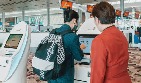 2 passengers using the automated bag drop at Singapore’s Changi Airport