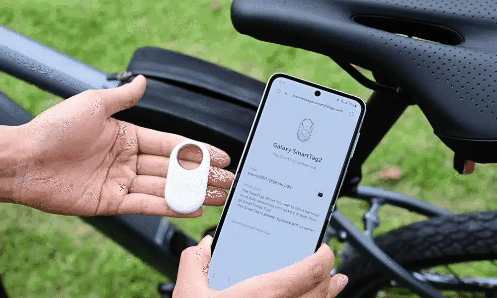 A person scans a SmartTag2 with a Samsung Galaxy phone, with a bicycle in the background