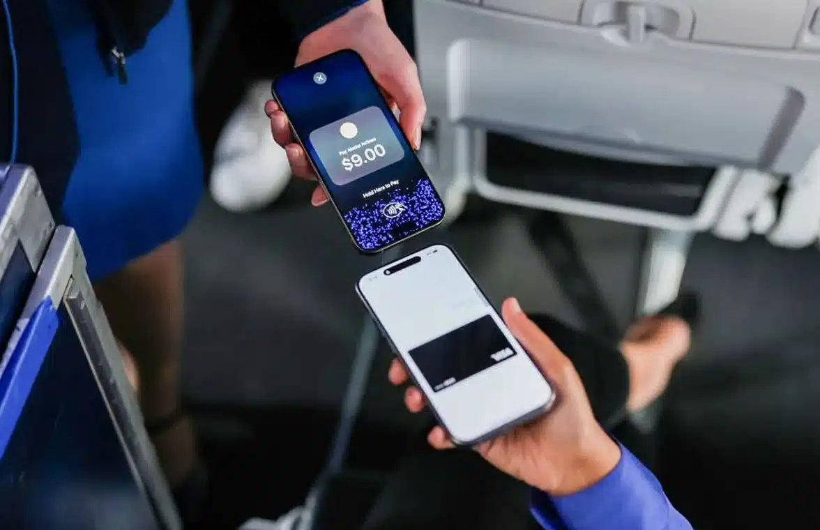 Customer making contactless payment on a Alaska Airlines' flight attendant's iPhone using Apple Tap to Pay