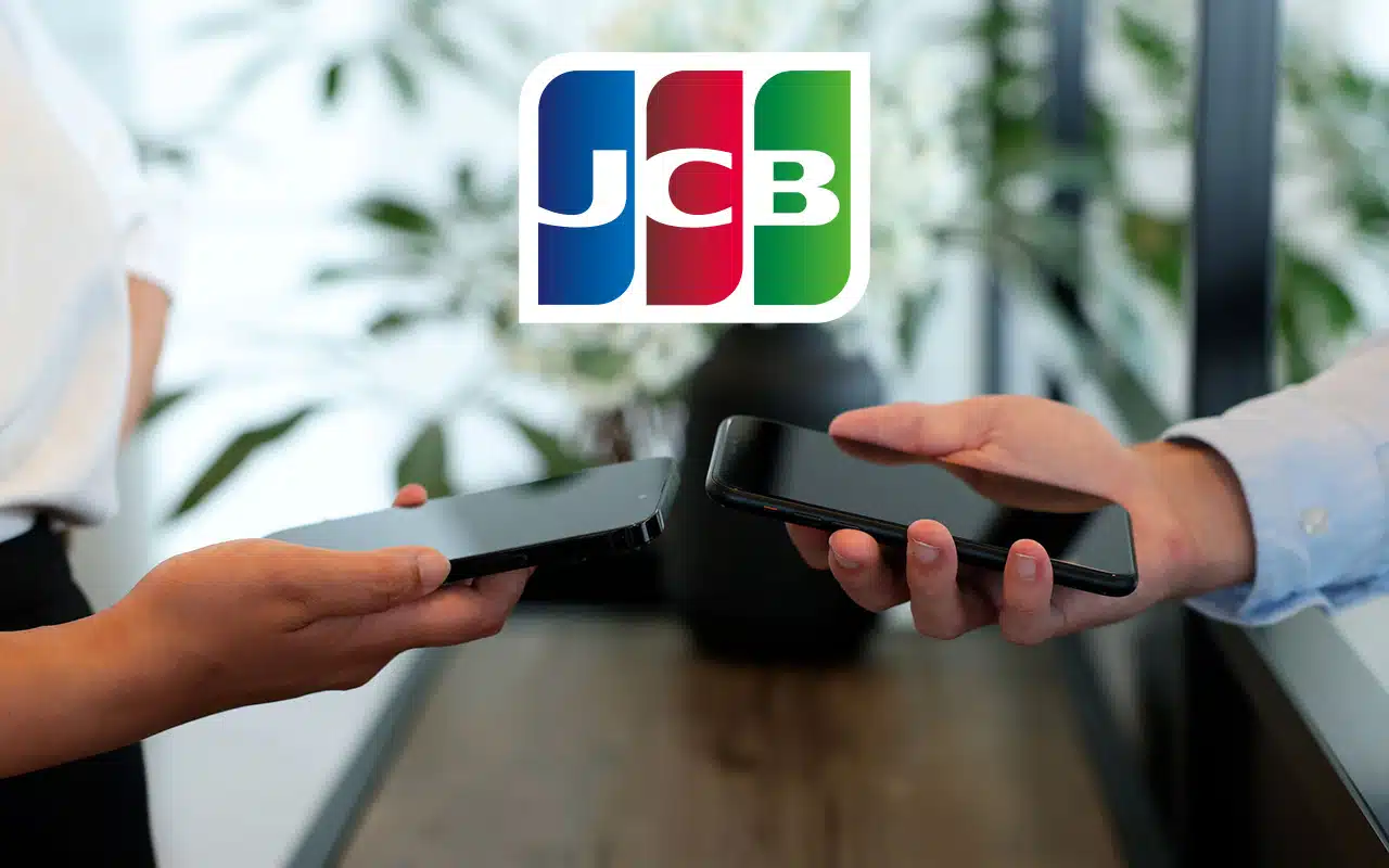 Two phones transferring CBDC via NFC, with JCB logo overlaid